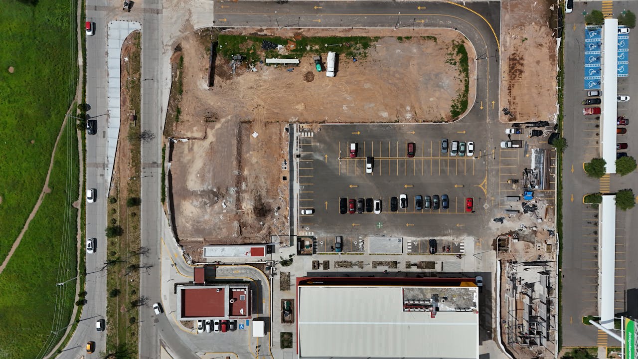 Top-down view of a parking lot beside a construction site in Aguascalientes, Mexico.